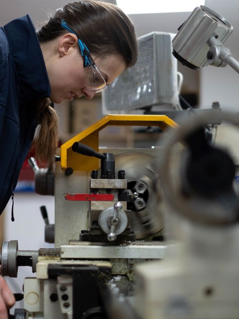 AquaLife Team Member working on a lathe