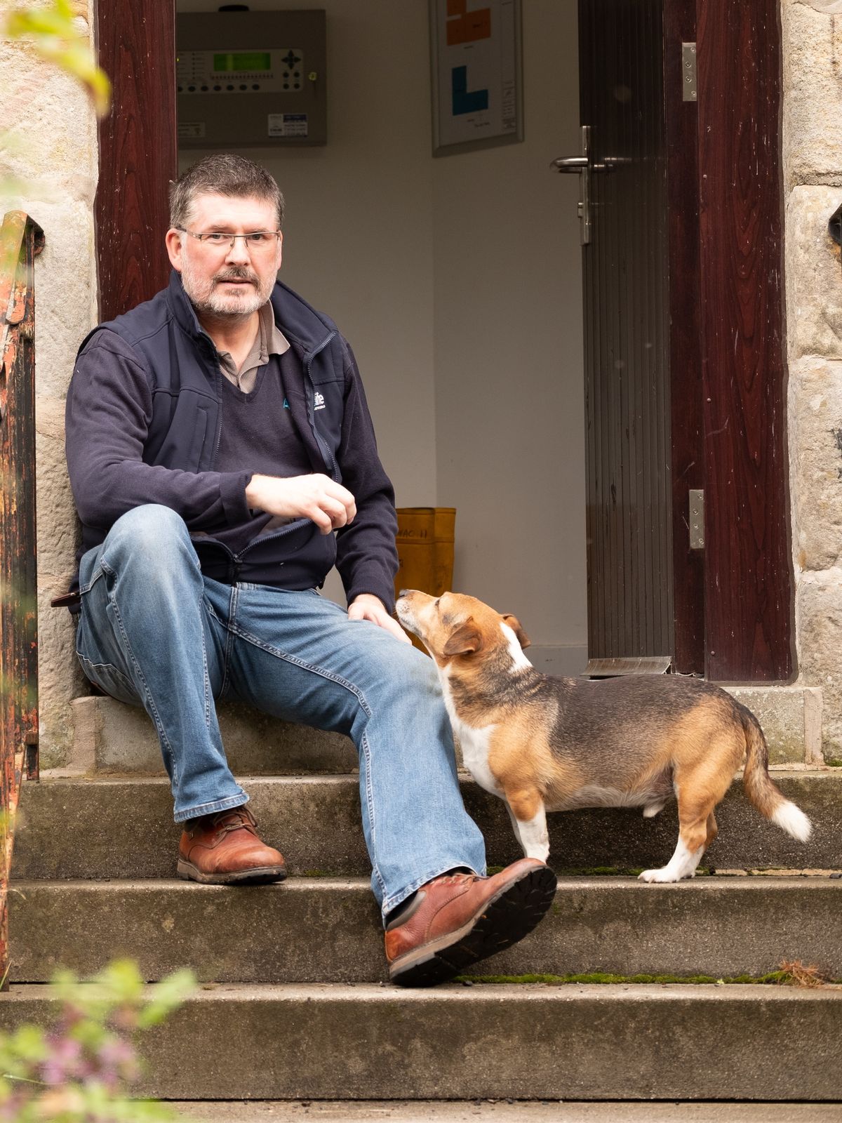 An Aqualife Team member sitting at the front door with a dog